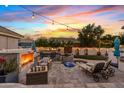 Outdoor oasis with a fireplace, seating, putting green and lounge chairs perfect for relaxing and entertaining at 2643 E Tamarisk St, Gilbert, AZ 85296