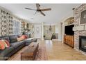 Bright living room with wood floors, a brick fireplace, and a comfortable seating arrangement for relaxation and entertainment at 2643 E Tamarisk St, Gilbert, AZ 85296