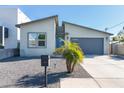 Contemporary single-story home with a gray garage door, modern mailbox, and desert landscaping at 2819 N 28Th Pl, Phoenix, AZ 85008