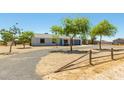 Charming single-story home with an attached garage, gravel yard, and rustic fence at 28213 N Holly Rd, San Tan Valley, AZ 85143