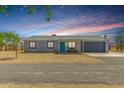 Charming single-story home with a gravel front yard, blue door, and attached garage at 28213 N Holly Rd, San Tan Valley, AZ 85143