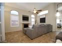 Spacious living room with a fireplace, high ceilings, ceiling fan, and lots of natural light at 3547 W Whispering Wind Dr, Glendale, AZ 85310