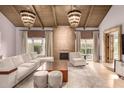 Bright living room features a fireplace, beamed ceilings, and stylish chandelier lighting at 6000 E Camelback E Rd # 7707, Scottsdale, AZ 85251