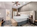 Bedroom featuring a king bed, stylish accent wall, and en-suite bath with soaking tub at 6000 E Camelback E Rd # 7707, Scottsdale, AZ 85251