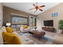 Cozy staged living room with stylish furniture, large windows, and a ceiling fan at 6959 E Red Hawk Cir, Mesa, AZ 85207