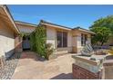 View of the home's entryway with stone pathway, lush green foliage, and brick accents at 7865 S Palm Dr, Tempe, AZ 85284