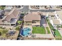 Aerial view of a backyard featuring a custom pool, hot tub, large grass area, and mature landscaping at 8615 S 45Th Gln, Laveen, AZ 85339