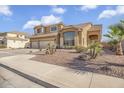 Exterior elevation of a stucco two story home with a three car garage and desert landscaping at 8615 S 45Th Gln, Laveen, AZ 85339