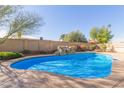 Sparkling blue swimming pool with rock waterfall feature, and a well-maintained concrete patio at 8749 W Clarendon Ave, Phoenix, AZ 85037