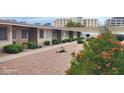 A front exterior of the property showcasing the tan exterior, neutral landscaping, and pedestrian walkway at 10540 W Coggins Dr # 1C, Sun City, AZ 85351