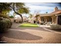 A large backyard with gravel and a section of artificial grass, and a covered patio at 1119 S Presidio Dr, Gilbert, AZ 85233