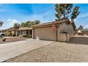 Single-story home featuring a two-car garage, covered entry, and desert landscaping at 11616 S Jokake St, Phoenix, AZ 85044