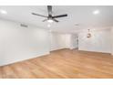 Spacious living room featuring wood-look flooring, a ceiling fan, and fresh white walls at 11616 S Jokake St, Phoenix, AZ 85044