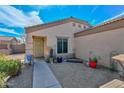 Inviting front exterior with gravel landscaping, small trees, decorative items, and walkway to front door at 12721 W Valentine Ave, El Mirage, AZ 85335