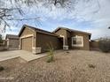 Attractive home with a well-manicured yard, desert landscaping, and a spacious driveway at 1298 S 222Nd Ln, Buckeye, AZ 85326