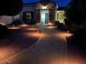 Well-lit walkway to a home's entrance with beautiful stone accents and desert landscaping at 13117 W Micheltorena Dr, Sun City West, AZ 85375