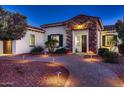 Attractive single-story residence featuring desert landscaping, walkway lighting, and a stone accented entry at 13117 W Micheltorena Dr, Sun City West, AZ 85375