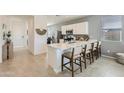 Bright kitchen featuring a quartz countertop island with seating, and sleek white cabinetry at 15579 W Williams St, Goodyear, AZ 85338