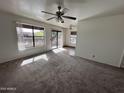 Bright living room features carpeted floors, ceiling fan, and sliding glass doors to the balcony at 16657 E Gunsight Dr # 296, Fountain Hills, AZ 85268