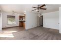 Open-concept living space with ceiling fan, carpeted living room, tile floored dining area and kitchen at 16657 E Gunsight Dr # 296, Fountain Hills, AZ 85268