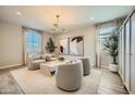 Bright living room featuring neutral furniture, decor, and large windows for ample natural light at 16681 W Charlotte Dr, Surprise, AZ 85387