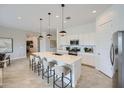 Bright kitchen featuring a large island with bar seating, stainless steel appliances, and modern pendant lighting at 16781 W Bronco Trl, Surprise, AZ 85387