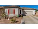 Charming single-story home with well-manicured desert landscaping, a two-car garage, and decorative red shutters at 17704 W Tasha Dr, Surprise, AZ 85388