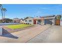 Inviting home with a fresh green lawn and a driveway leading to a grey garage, enhanced by solar panels at 2008 E Mitchell Dr, Phoenix, AZ 85016