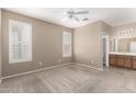 Comfortable carpeted bedroom featuring plantation shutters and ensuite bathroom at 2101 S Yellow Wood -- # 22, Mesa, AZ 85209