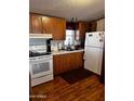 Functional kitchen featuring white appliances, wooden cabinets, and a practical layout at 2121 N Center St # 138, Mesa, AZ 85201