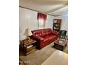 Comfortable living room showcases a red sofa, side tables with lamps, and a bookshelf at 2121 N Center St # 138, Mesa, AZ 85201