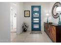 Inviting entryway features a blue front door, light tile flooring, and a decorative mirror at 26509 W Ponderosa Ln, Buckeye, AZ 85396