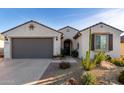 Charming single-story home showcasing a stucco exterior, desert landscaping, and a gray two-car garage at 26509 W Ponderosa Ln, Buckeye, AZ 85396