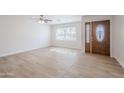 Bright living room featuring neutral-toned vinyl flooring, a window, and a stylish front door at 2728 W Redfield Rd, Phoenix, AZ 85053