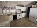 Well-lit kitchen featuring white cabinets, black appliances, and brick-like patterned backsplash at 4065 E University Dr # 556, Mesa, AZ 85205