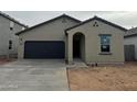 Single-story home featuring a dark garage door, arched entryway and desert landscaping at 4159 E Kolin Ln, San Tan Valley, AZ 85143