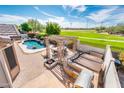 Aerial view of backyard with kidney-shaped pool, outdoor kitchen, fire pit, pergola with dining table, and spa at 4488 N 155Th Ave, Goodyear, AZ 85395