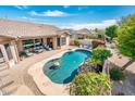 An aerial view of a backyard featuring a kidney-shaped pool, waterfall feature, and patio with outdoor seating at 4488 N 155Th Ave, Goodyear, AZ 85395