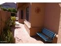 Private outdoor patio space with tiled flooring, sun decor, and a blue wrought iron bench at 455 W Gary Ave, Gilbert, AZ 85233