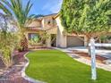 Inviting home exterior featuring a lush lawn, mature landscaping, and a welcoming entryway at 5137 W Quail Track Dr, Phoenix, AZ 85083