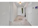 Clean, neutral hallway with tiled floor, elegant lighting and modern thermostat for comfort at 5137 W Quail Track Dr, Phoenix, AZ 85083