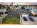 A scenic aerial view showcases the home's well-maintained yard, landscaping, and neighborhood at sunset at 8037 W Sweetwater Ave, Peoria, AZ 85381