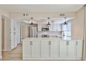 Bright kitchen featuring white cabinets, stainless steel appliances, and modern pendant lighting at 8151 E Del Joya Dr, Scottsdale, AZ 85258