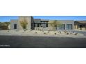 Contemporary home's exterior shows natural stone accents, desert landscaping, and a modern design at 12856 E Rosewood Dr, Scottsdale, AZ 85255