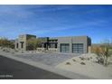 Modern exterior showcasing a contemporary home with a paver driveway and desert landscaping under a blue sky at 12856 E Rosewood Dr, Scottsdale, AZ 85255