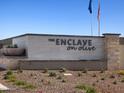 Community entrance featuring stone signage surrounded by desert landscaping against a clear blue sky at 17426 W Eva St, Waddell, AZ 85355