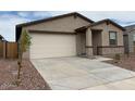Attractive single-story home with a two-car garage and a concrete driveway at 17426 W Eva St, Waddell, AZ 85355