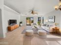 Bright living room with neutral decor, tile floors, modern furnishings, and sliding glass doors to the backyard at 29219 N Red Finch Dr, San Tan Valley, AZ 85143