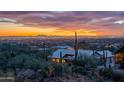 Expansive aerial view of a home nestled among desert foliage with captivating city lights and mountain views in the background at 3086 N Herrala Way, Apache Junction, AZ 85119