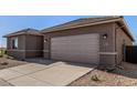 New construction home featuring a two-car garage and low maintenance desert landscaping at 31476 N Hayweather Ln, San Tan Valley, AZ 85143